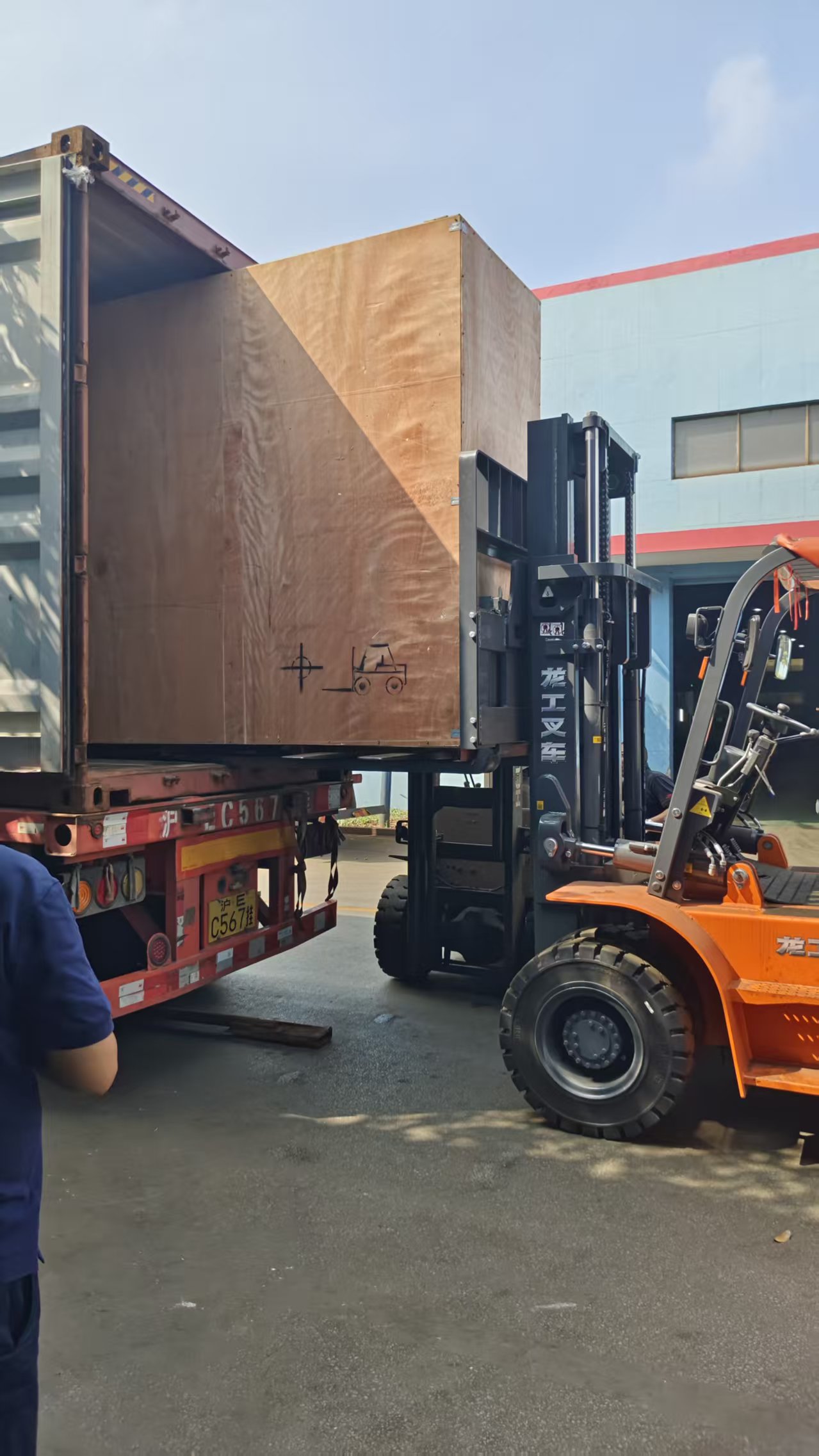 Carretilla elevadora cargando una caja de máquina herramienta en un contenedor de transporte